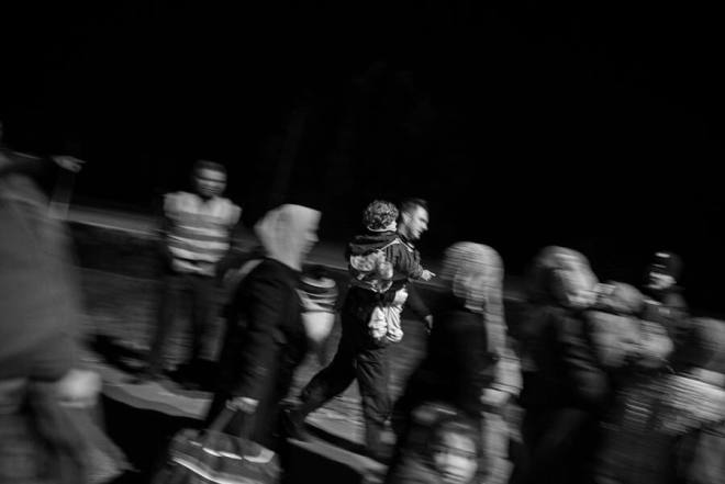 Erste Hilfe Polizist trägt Flüchtlingskind – aus: Reportagen über Flucht, Vertreibung, Migration, Neuanfang